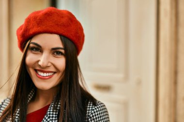 Genç İspanyol kadın gülümseyerek şehirde mutlu mesut dikiliyor..