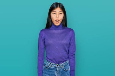 Güzel, genç Asyalı kadın gündelik kıyafetler giyiyor. Şaşırmış ve şaşırmış bir ifade, korku ve heyecanlı bir yüz ifadesi var.. 