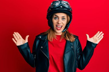 Motosiklet kaskı takan İspanyol genç kadın zaferi mutlu bir gülümsemeyle ve kazanan ifadeyle kutluyor. 