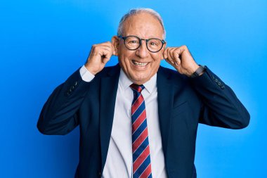 Beyaz adam takım elbise ve kravat takıyor. Gülümsüyor, kulakları parmaklarıyla çekiyor. Komik bir jest. deneme sorunu 