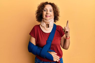 Güzel, orta yaşlı, boyun tasması ve kol askısı takan olgun bir kadın bir fikir ya da soru işareti ile şaşırdı. 