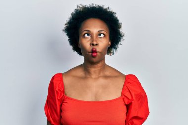 Genç Afro-Amerikalı kadın günlük kıyafetler giyip dudaklarıyla balık suratı yapıyor. Çılgınca ve komik bir jest. Komik ifade. 