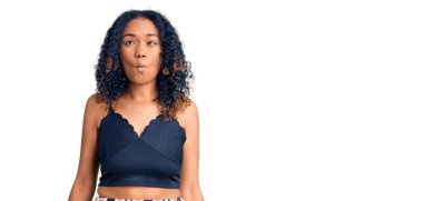 Genç Afro-Amerikalı kadın günlük kıyafetler giyip dudaklarıyla balık suratı yapıyor. Çılgınca ve komik bir jest. Komik ifade. 