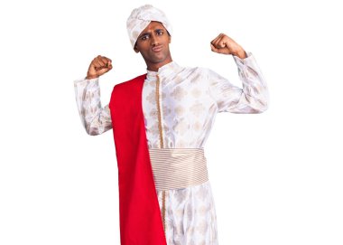 Gelenek giyinmiş Afrikalı yakışıklı bir adam Sherwani sari elbisesi giyiyor ve gururla gülümsüyor. fitness konsepti. 