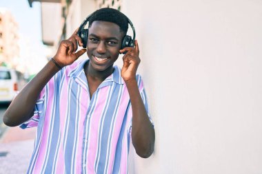 Şehrin caddesinde kulaklık kullanan Afrikalı genç bir Amerikalı..