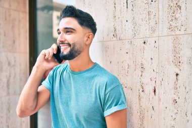 Şehirdeki akıllı telefondan konuşan, ciddi bir suratı olan genç bir Arap..