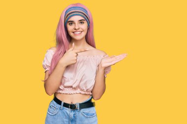 Pembe saçlı genç İspanyol kız kameraya hayret ediyor ve gülümsüyor.. 