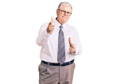İş kıyafetleri giymiş yaşlı gri saçlı adam mutlu ve komik yüzüyle kamerayı işaret ediyor. iyi enerji ve titreşimler. 