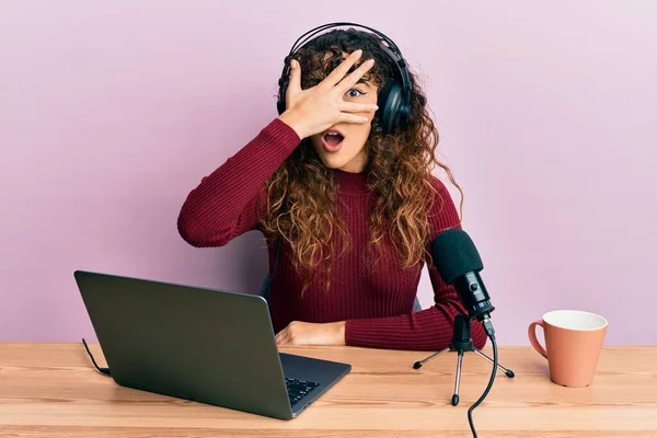 Young Hispanic Girl Working Radio Office Peeking Shock Covering Face —  Fotos de Stock
