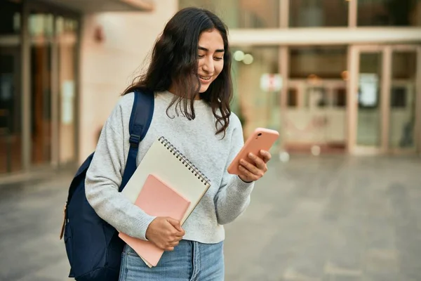 若いです中東学生女の子笑顔幸せな使用スマートフォンで市内 — ストック写真