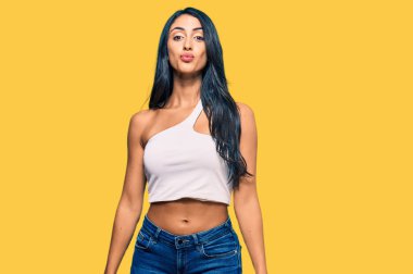 Güzel İspanyol kadın, günlük kıyafetler giyip kameraya bakıyor. Canlı yayında öpücük yolluyor. Sevimli ve seksi. aşk ifadesi. 