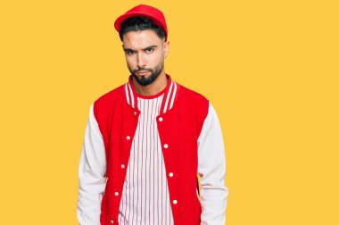 Sakallı, beyzbol forması giyen, kuşkucu ve gergin genç bir adam sorun yüzünden üzgün. negatif kişi. 