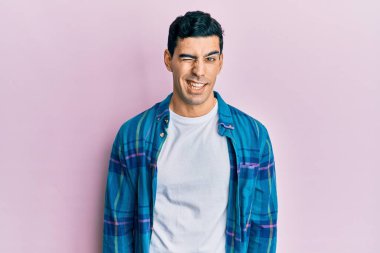 Yakışıklı, sıradan kıyafetler giyen, kameraya seksi bir ifadeyle bakan, neşeli ve mutlu yüzlü bir İspanyol.. 