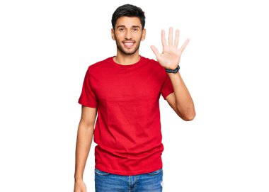Young handsome man wearing casual red tshirt showing and pointing up with fingers number five while smiling confident and happy. 