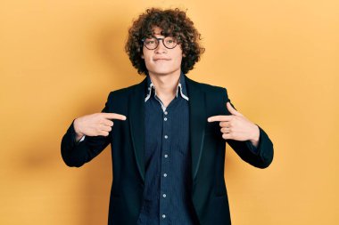 İş ceketi ve gözlük takan yakışıklı genç adam. Kendine güvenen, gülümseyen, kendini gururlu ve mutlu gösteren.. 