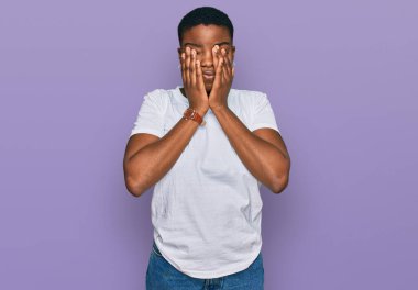 Gündelik beyaz tişört giyen genç Afro-Amerikalı kadın yorgunluk ve baş ağrısı için gözlerini ovuşturuyor, uykulu ve yorgun ifade. görme sorunu 