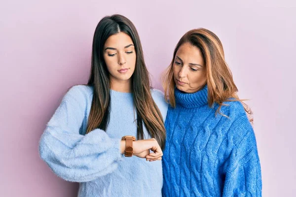 西班牙裔家庭的母亲和女儿都穿着羊毛衫 带着腕表检查时间 既轻松又自信 — 图库照片