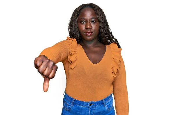 穿着休闲装的年轻非洲女人看上去很不高兴 很生气 用拇指低下的姿势表示拒绝和消极 不好的表达方式 — 图库照片