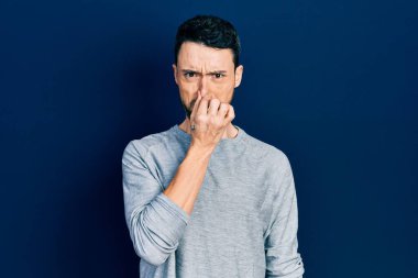 Gündelik kıyafetler giyen genç İspanyol adam pis ve iğrenç bir koku alıyor, dayanılmaz bir koku, nefesini burnunda tutuyor. Kötü kokuyor. 