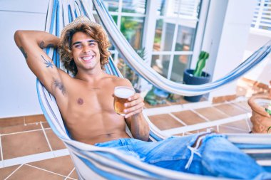 Genç İspanyol adam terasta hamakta uzanmış bira içerek rahatladı..