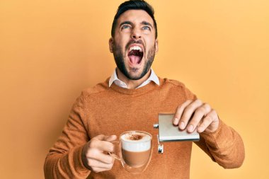 Genç İspanyol adam alkollü bir fincan kahve içiyor kızgın ve kızgın çığlıklar atıyor öfkeyle bağırıyor, öfkeyle yukarı bakıyor.. 