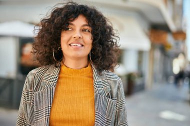 Genç İspanyol iş kadını şehirde mutlu mesut ayakta duruyor..