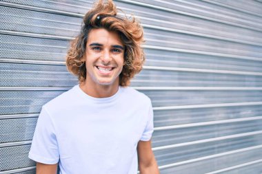 Genç, yakışıklı, gülümseyen bir İspanyol. Şehrin caddesinde mutlu bir şekilde yürüyor.