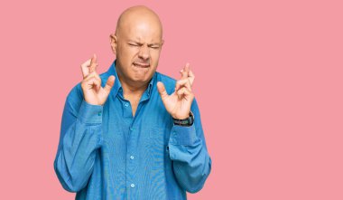 Orta yaşlı, kel, sıradan kıyafetler giyen, el kol hareketi yapan umut ve gözlerle gülümseyen bir adam. Şans ve batıl inançlar. 