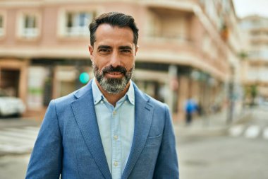 Orta yaşlı işadamı şehirde mutlu mesut dikilirken.