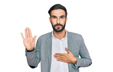 İş kıyafetleri giymiş, elleri göğsünde ve avuçları açık yemin eden genç İspanyol bir adam sadakat yemini ediyor. 