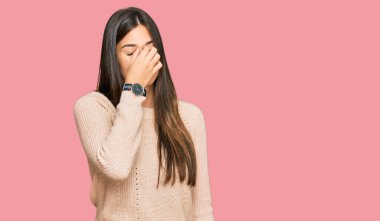 Kış süveteri giyen esmer kadın yorgun burnu ve gözleri ovuşturup yorgun ve baş ağrısı çekiyor. Stres ve hüsran kavramı. 