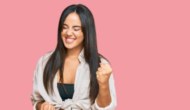 Gündelik giysiler giyen genç ve güzel İspanyol kız kolları havada ve gözleri kapalı bir şekilde başarıyı kutluyor ve şaşırıyor. Kazanan konsept. 