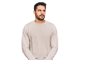 Gündelik kıyafetler giyen genç İspanyol adam gülümseyip yan tarafa bakıyor ve düşünüyor.. 