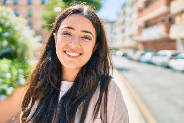 Genç İspanyol kadın gülümseyerek şehirde mutlu mesut yürüyor..