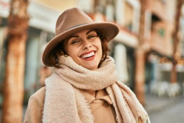 Şık giyinen genç İspanyol kadın şehirde dikiliyor..