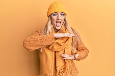 Kışın yün kazak giyen, büyük ve büyük beden işareti gösteren el kol hareketleri yapan beyaz bir kadın. Ölçü sembolü. Kameraya bakıp gülümsüyor. ölçüm kavramı. 