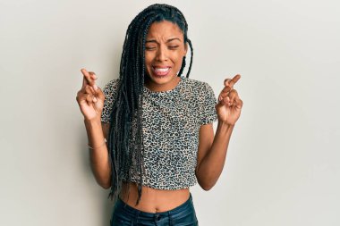 Afro-Amerikalı kadın günlük kıyafetler giyip umut ve gözlerin kapalı gülümseyerek el sallıyor. Şans ve batıl inançlar. 