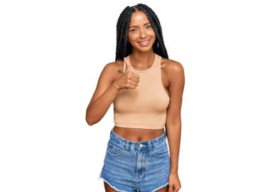 Gündelik giysiler giyen güzel İspanyol kadın elleriyle mutlu bir jest yapıyor. Kameraya bakıp başarıyı gösteren ifade. 