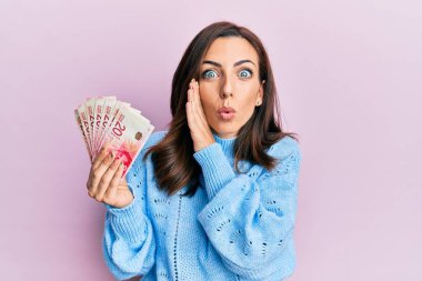 Genç esmer kadın elinde 20 İsrail şekeri tutuyor. El ele banknotlar. Gizli dedikodular, kötü niyetli konuşmalar fısıldıyor. 