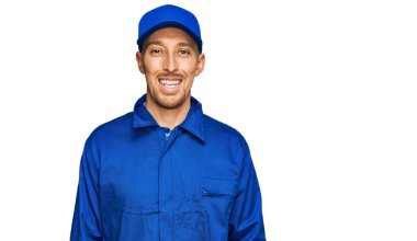 Kel, sakallı, inşaatçı tulumu giyen mutlu ve havalı bir gülümsemesi olan bir adam. şanslı kişi. 