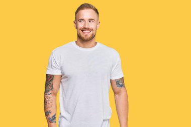 Genç İrlandalı sıradan kıyafetler giymiş, gülümseyen, yan tarafa bakan ve düşünen.. 