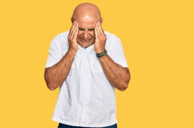 Yetişkin, bıyıklı, elleri kafasında, günlük beyaz gömlek giyen, stres yüzünden başı ağrıyan orta doğulu bir adam. migren ağrısı. 