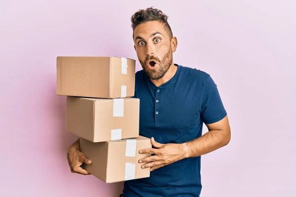 Bonito Homem Com Barba Segurando Pacotes Entrega Assustado Surpreso Com — Fotografia de Stock