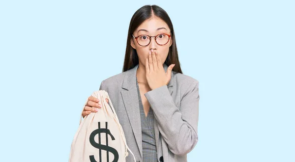 Jovem Chinesa Vestindo Terno Negócios Segurando Saco Dólares Cobrindo Boca — Fotografia de Stock