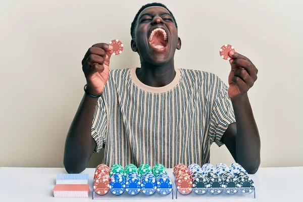 Jovem Afro Americano Jogando Pôquer Segurando Fichas Cassino Irritado Louco — Fotografia de Stock