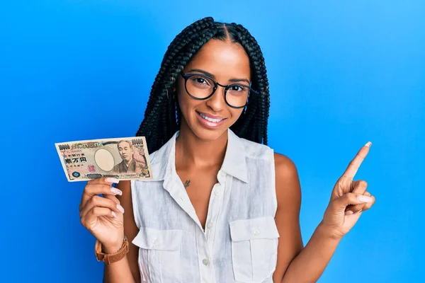 Hermosa Mujer Hispana Sosteniendo Billetes Yen Japoneses Sonriendo Feliz Señalando —  Fotos de Stock