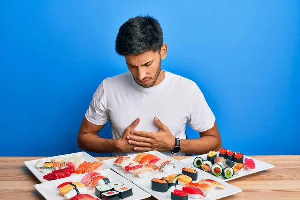 Young Handsome Man Eating Sushi Sitting Table Hand Stomach Because — Foto de Stock