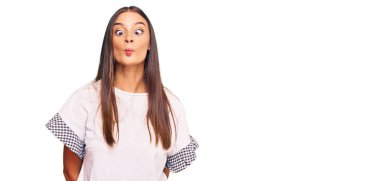 Gündelik kıyafetler giyen genç İspanyol kadın dudaklarıyla balık suratı yapıyor, çılgınca ve komik bir jest. Komik ifade. 