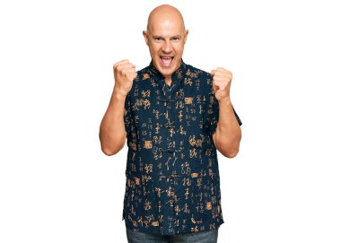 Orta yaşlı kel bir adam gündelik giysiler içinde gururla bağırıyor zaferi kutluyor ve başarıyı kollarını kaldırarak kutluyor. 