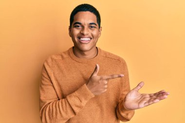 Sıradan bir süveter giyen genç, yakışıklı İspanyol adam kameraya hayret ediyor ve gülümsüyor.. 